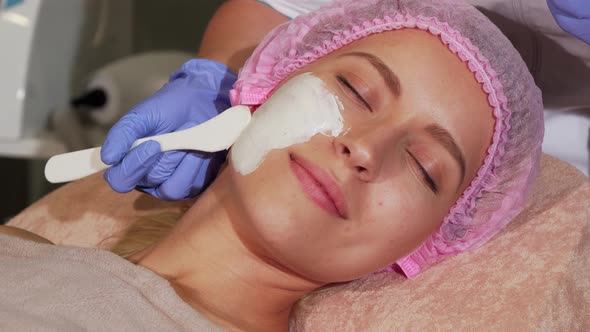 Happy Woman Getting Facial Treatment at the Beauty Clinic