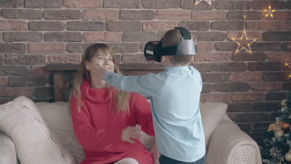 Child with VR Headset Embraces Smiling Fair Haired Mother