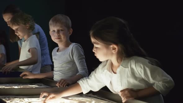 Boy Looking at Camera in Sand Animation Class