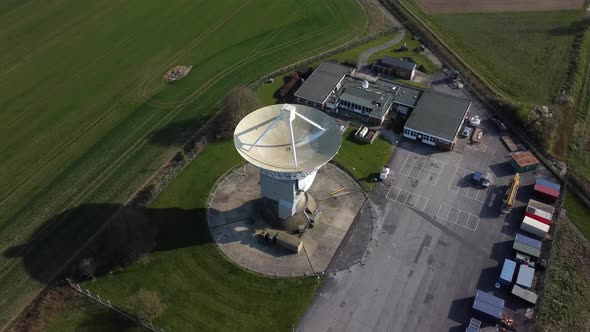 Drone shot orbiting a large satellite dish and observatory in England