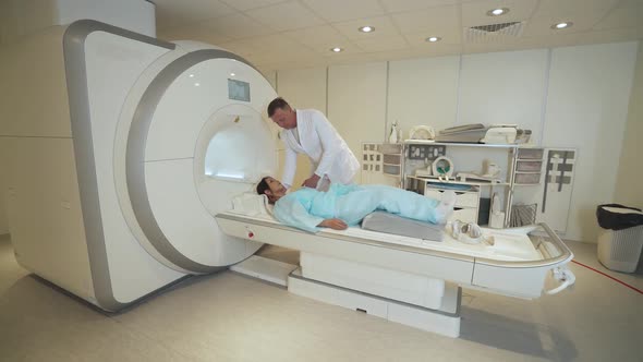 Magnetic Resonance Imaging Adult Man Doctor Performs a Magnetic Tomographic Examination of a Young