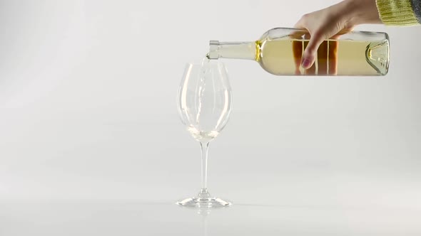 Pouring Sparkling White Wine Into a Wineglass with Bottle, White, Slowmotion