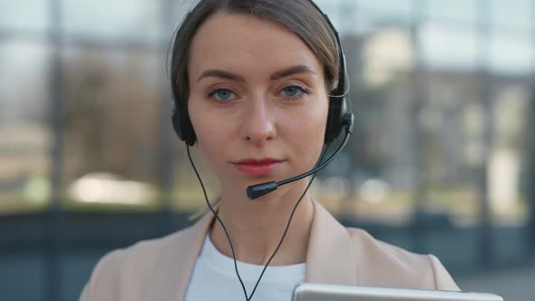 Call Center Agent with Headset and Laptop Standing Outdoors