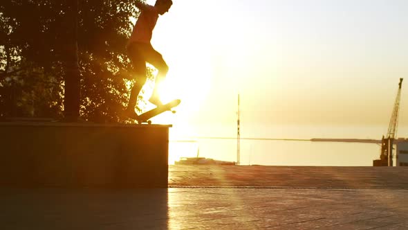 Young Caucasian Male Jumping From Parapet on Skateboard in Slowmotion