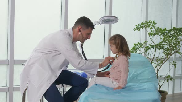 The Doctor Listens to the Lungs of the Child With a Stethoscope