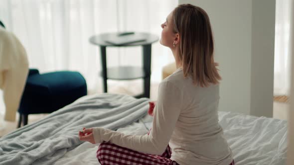 Handsome blonde woman doing meditation in the bed