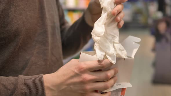 Protection Against Infection During the Coronavirus Pandemic. A Man Takes Out New Rubber Gloves From