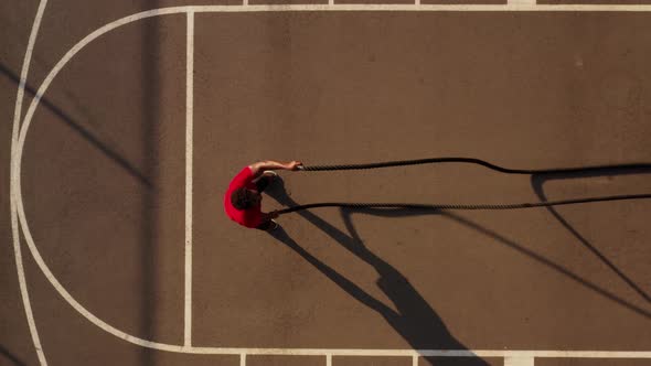 Aerial shot of a man working out with battle ropes