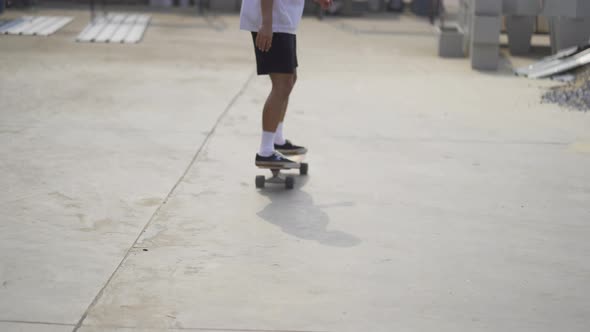 Young Asian man playing skateboard sweeping turns on surf skate on street road