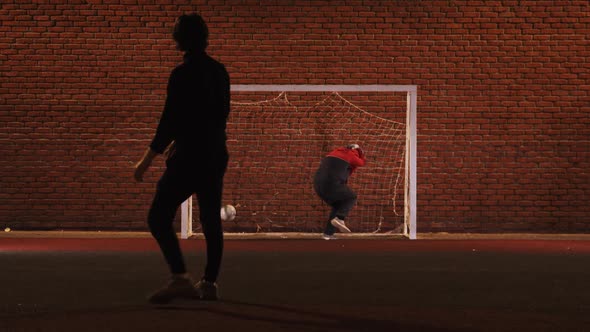 Two Young Men Friends Playing Football on the Playground at Night alt