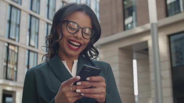 Happy Businesswoman Using Smartphone Outdoors