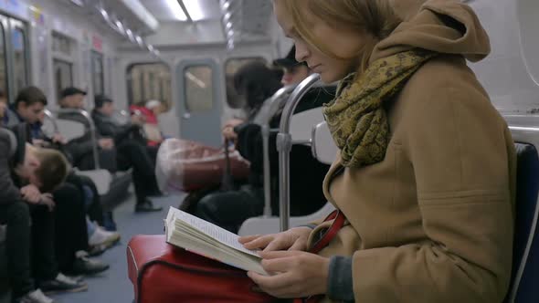 Woman Reading a Book in Tube Train