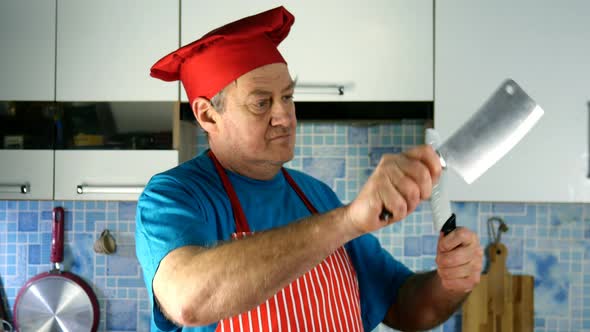 Senior Adult Cook Caucasian Ethnicity in Chefs Hat Sharpens Knife on Knife on Domestic Kitchen