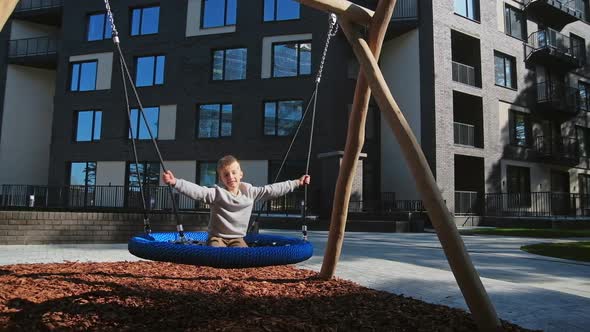 Child Boy Swinging in Urban Playground Slow Motion