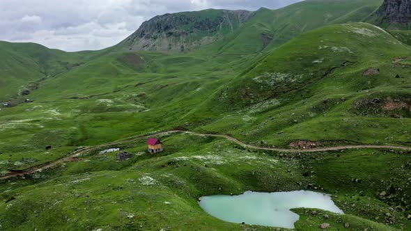 Small Lake And Farmhouse Among Green Hills In Mountains Of Georgia