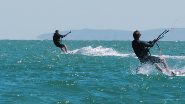 Kiters Ride Waves on Twintip