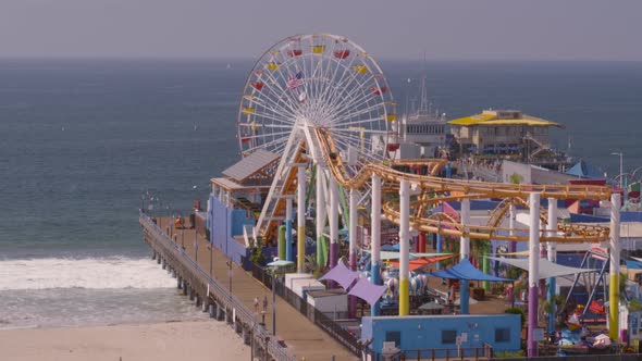 Aerial of Ferris wheel and amusement park rides at Pacific Park