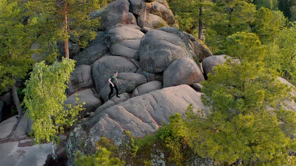 The traveler is climbing on the top of the wild mount The Krasnoyarsk Stolby