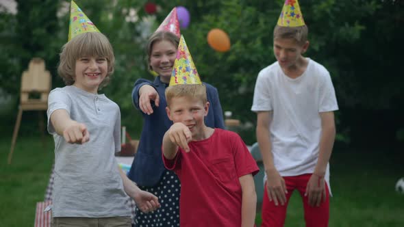 Group of Children and Teenagers Teasing Pointing at Camera Laughing Standing in Summer Spring Park