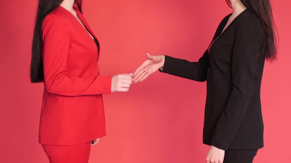 Two Business Partners Shaking Hands in Agreement on Red Background