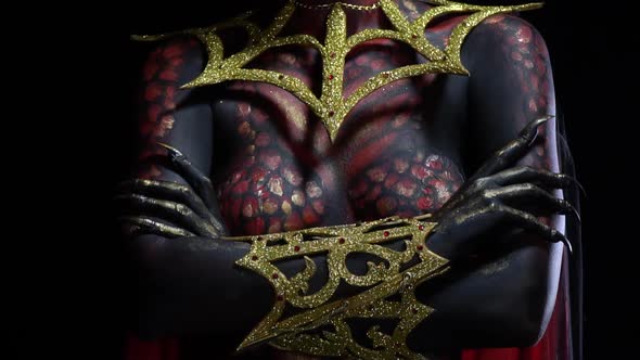 Close up of the demon womans hands with golden armor and long nails