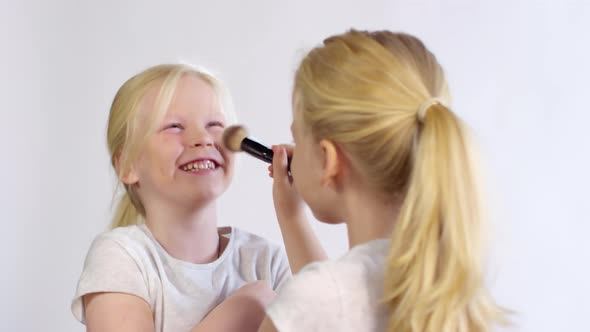 Blonde Twins Fooling with Make-Up Brush