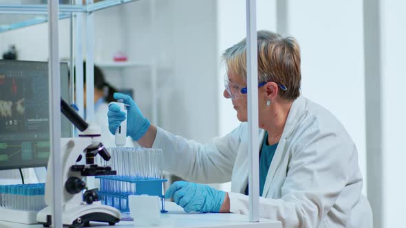 Senior Scientist Woman Pipetting Liquid To Test Tube