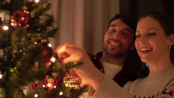 Happy Couple Decorating Christmas Tree at Home