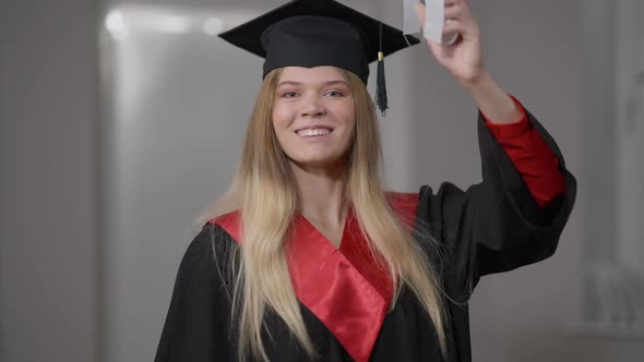 Smart Confident Smiling Woman Posing with Rolled Degree Certificate Indoors