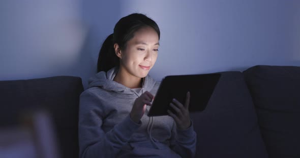 Woman use of tablet computer at night