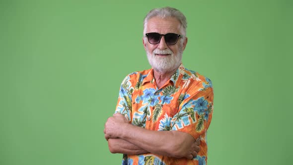 Handsome Senior Bearded Tourist Man Ready for Vacation Against Green Background