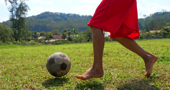 Rural Boy Kicking A Soccer Ball 