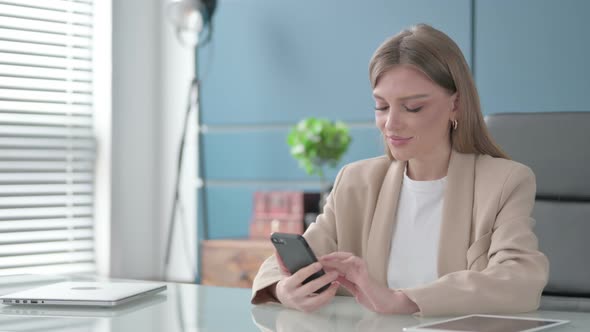 Businesswoman Using Smartphone in Office