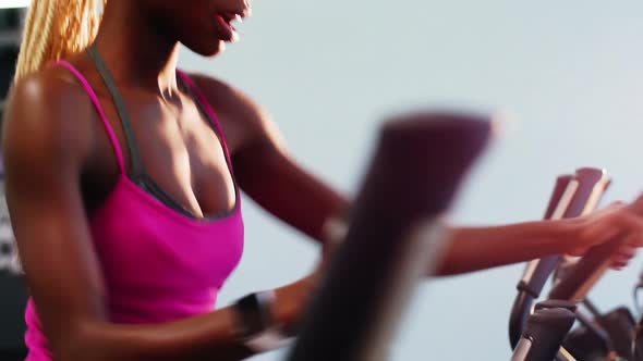 Fit woman exercising on cross trainer