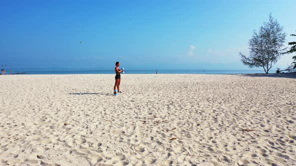 Beautiful beauty models travelling spending quality time at the beach on clean white sand and blue b