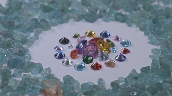Colorful Diamonds Spin Around On Rough Blue Stone Background.
