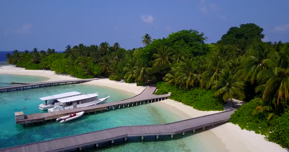 Natural fly over travel shot of a white sand paradise beach and blue water background in colorful 