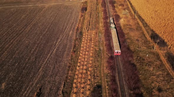 Aerial drone view of a moving train in Moldova in autumn. Yellowed vegetation, slow motion