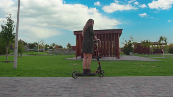 Girl in Dress Rides Electric Kick Scooter