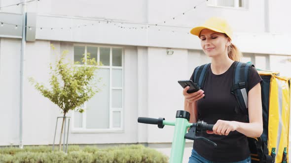 Portrait of Female Courier with Thermal Backpack Browsing Address on Mobile