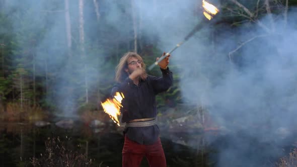 Young Man Dancing with Fire Stick and Smoke