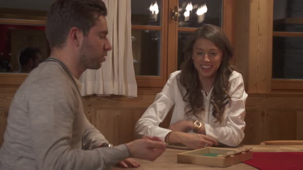A man and woman couple lifestyle playing a board game.