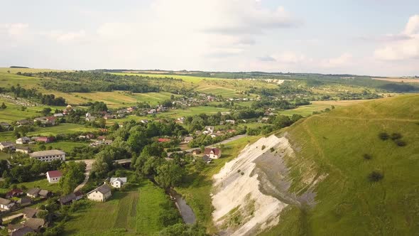 Aerial view of a small village between green summer hills in ukrainian Carpathian mountains