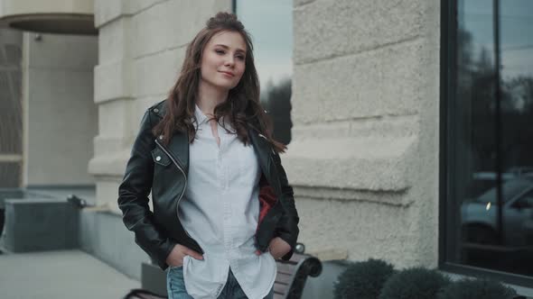 Portrait of a Young Woman in a Leather Jacket on the Street. Hipster Girl Walking in the City