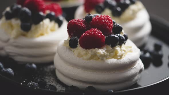 Delicious Mini Pavlova Meringue Desserts Served with Frozen Frosty Berries