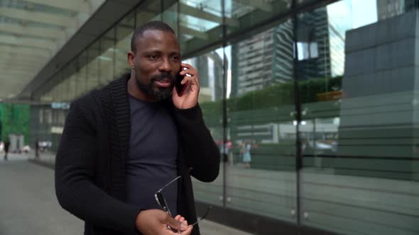 Cool Black Guy Is Walking on Street and Talking By Cell Phone, Putting Off Sunglasses and Shouting