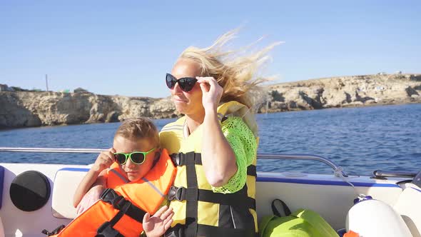 Mother and Child on a Pleasure Boat Sailing on the Sea on a Sunny Summer Day