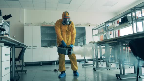 One Man Uses a Sprayer To Sanitize a Room During Pandemic.