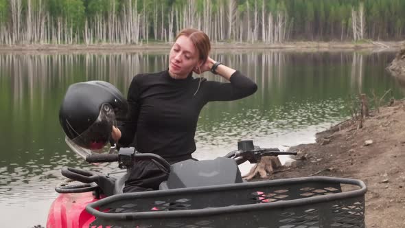 Woman on Quad Bike Using Smartwatch in Forest