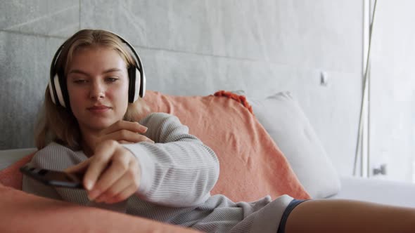 Caucasian woman listening to music in hotel room